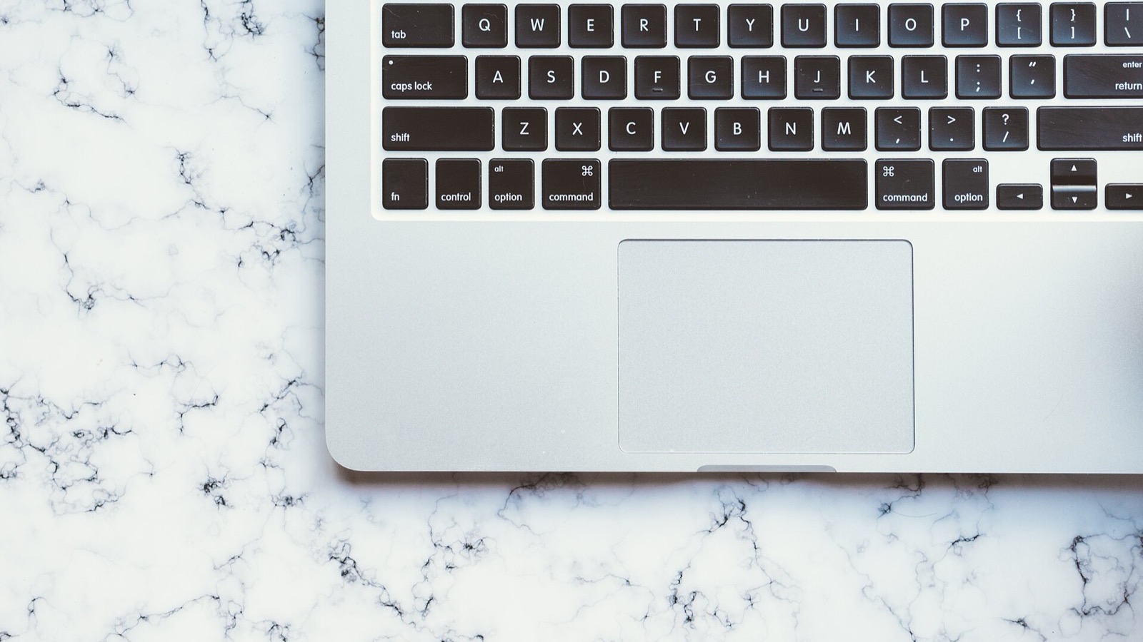 Top-down close-up of a silver desktop and laptop keyboard layout