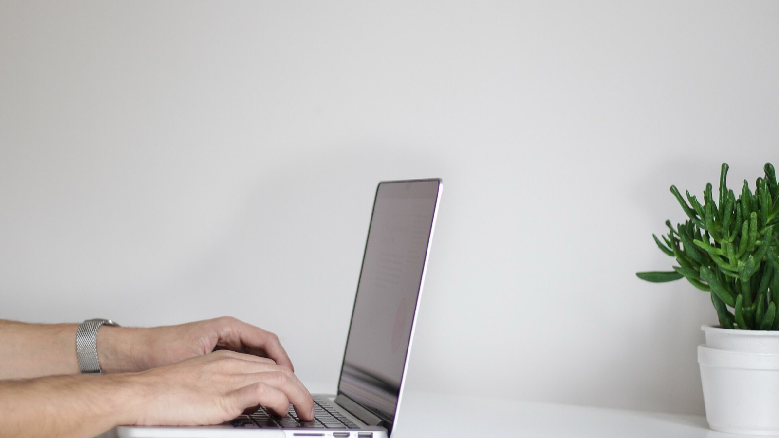 Minimalist writing workspace with a laptop and notebook for editing prose